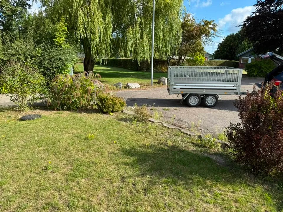 Trailer holdt i en have under en haveopgave